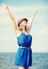 Image showing girl with hands up on the beach