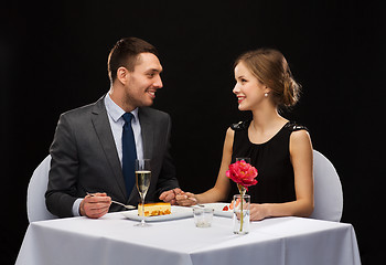 Image showing smiling couple eating dessert at restaurant