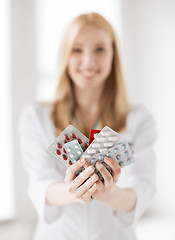 Image showing female doctor with packs of pills