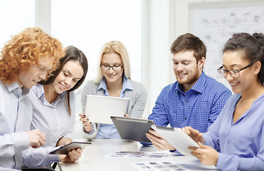 Image showing smiling team with table pc and papers working