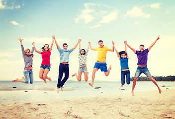 Image showing group of friends jumping on the beach