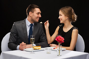 Image showing smiling couple eating dessert at restaurant