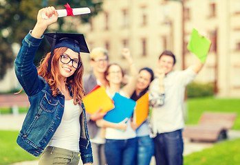 Image showing smiling teenage girl in corner-cap with diploma