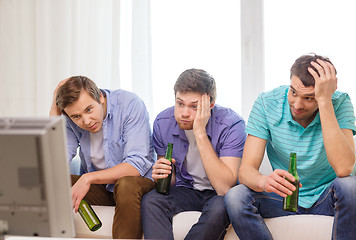 Image showing sad male friends with beer watching sports