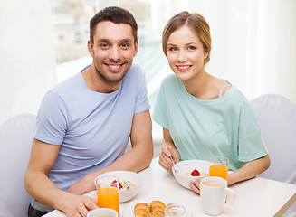 Image showing smiling couple having breakfast at home