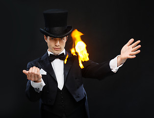 Image showing magician in top hat showing trick with fire