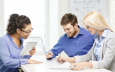 Image showing smiling team with table pc and papers working