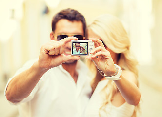 Image showing travelling couple taking photo picture with camera