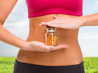 Image showing close up of female hands with bottle of capsules