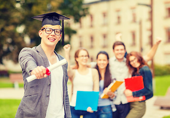 Image showing smiling teenage boy in corner-cap with diploma