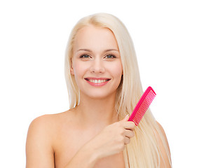 Image showing smiling woman with hair brush