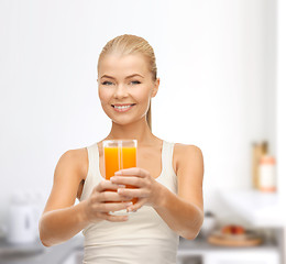 Image showing smiling woman holding glass of orange juice