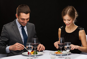 Image showing smiling couple eating main course at restaurant