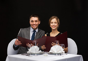 Image showing smiling couple with menus at restaurant