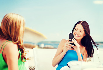 Image showing girls taking photo in cafe on the beach