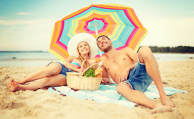Image showing smiling couple sunbathing on the beach