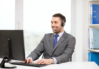 Image showing helpline operator with headphones and computer