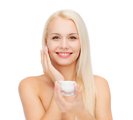 Image showing woman applying cream on her skin
