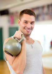 Image showing smiling man with kettlebell in gym