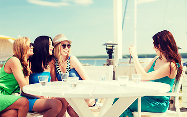 Image showing girls taking photo in cafe on the beach