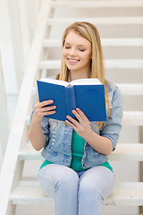 Image showing smiling teenage girl reading book
