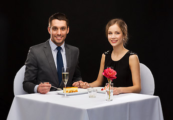 Image showing smiling couple eating dessert at restaurant