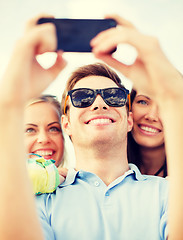 Image showing group of friends taking picture with smartphone