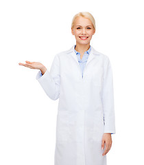 Image showing smiling female doctor holding something on hand