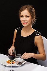 Image showing smiling young woman eating main course