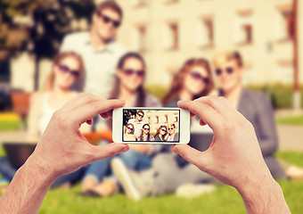 Image showing close up of hands making picture of group of teens