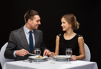 Image showing smiling couple eating main course at restaurant