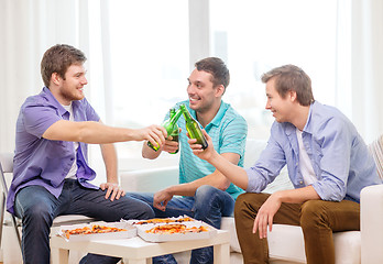 Image showing smiling friends with beer and pizza hanging out