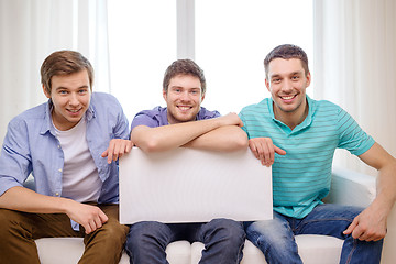 Image showing smiling male friends holding white blank board