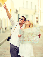 Image showing smiling couple in sunglasses with map in the city
