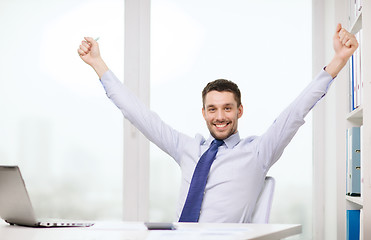 Image showing smiling businessman with laptop and documents