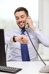 Image showing smiling businessman making call