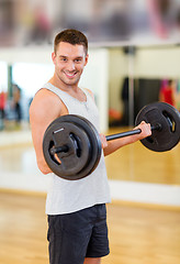 Image showing smiling man with barbell in gym