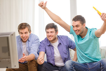 Image showing happy male friends with vuvuzela watching sports