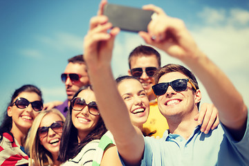 Image showing group of friends taking picture with smartphone