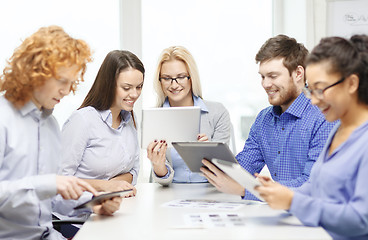 Image showing smiling team with table pc and papers working