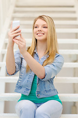 Image showing smiling female student with smartphone