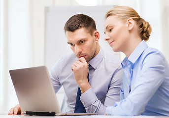 Image showing serious business couple with laptop computer