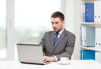 Image showing busy businessman with laptop and coffee