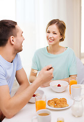 Image showing smiling couple having breakfast at home