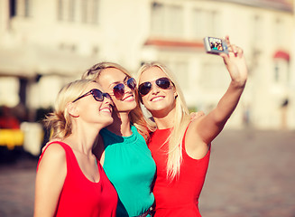 Image showing three beautiful girls taking picture in the city