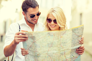 Image showing smiling couple in sunglasses with map in the city