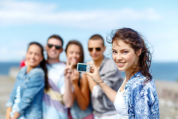Image showing happy teenagers taking photo outside