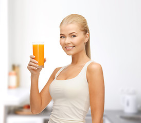 Image showing smiling woman holding glass of orange juice