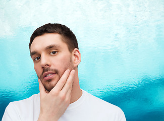 Image showing beautiful calm man touching his face