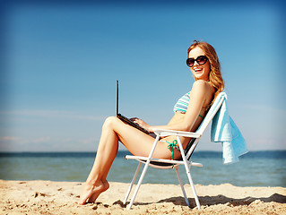 Image showing girl looking at tablet pc on the beach